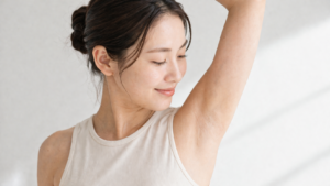 片腕を上げて脇を確認する女性