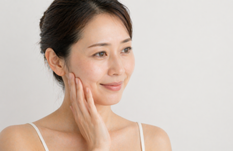 頬に手を当てて微笑む女性