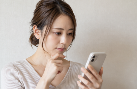 スマートフォンで調べものをする女性