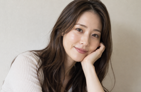 肘をついて微笑む女性