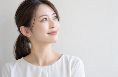 遠くを見て微笑む女性