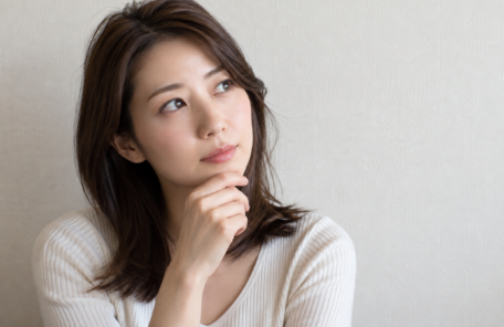 顎に手を当てて考える女性